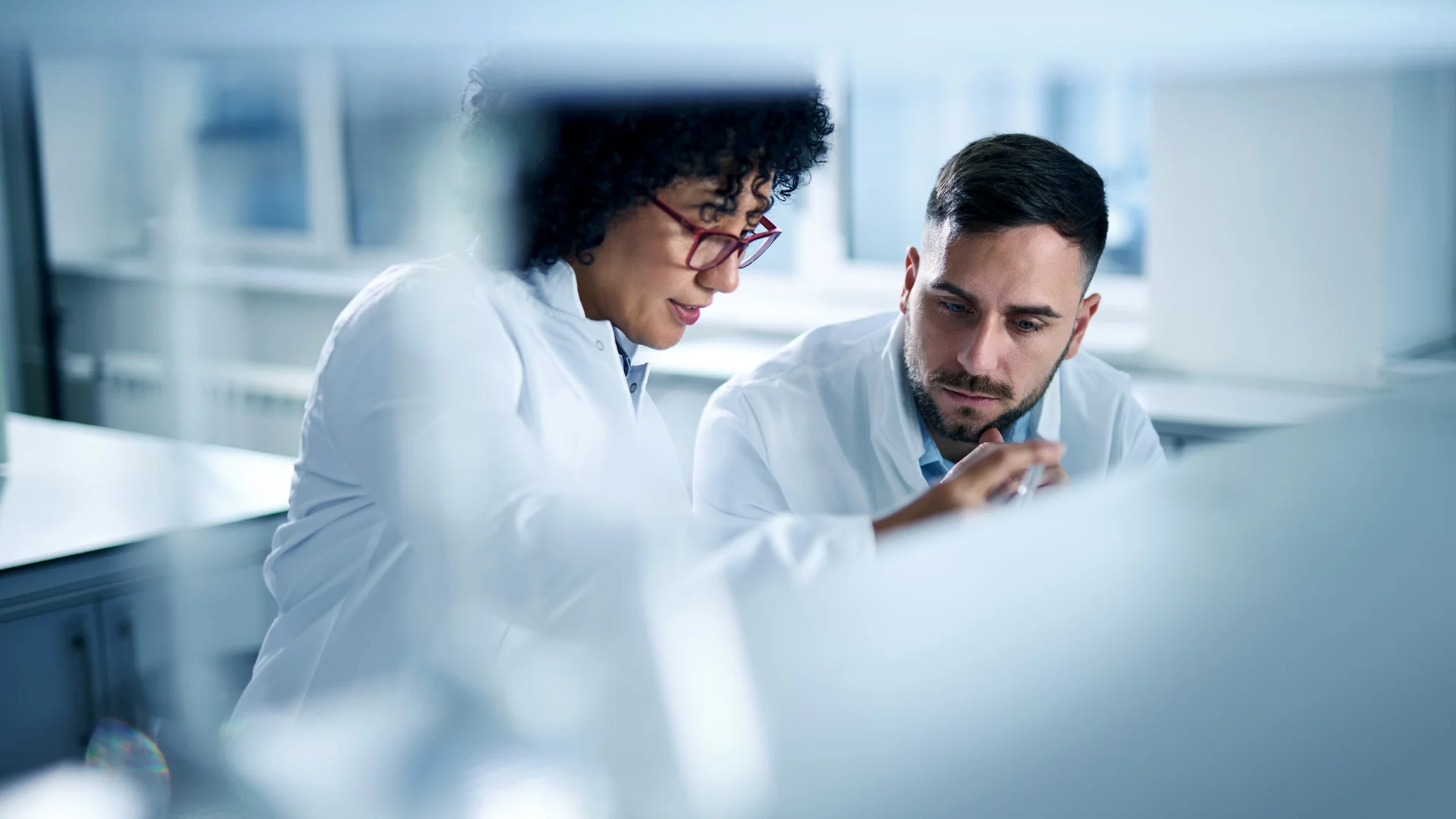 Two people in lab coats talking