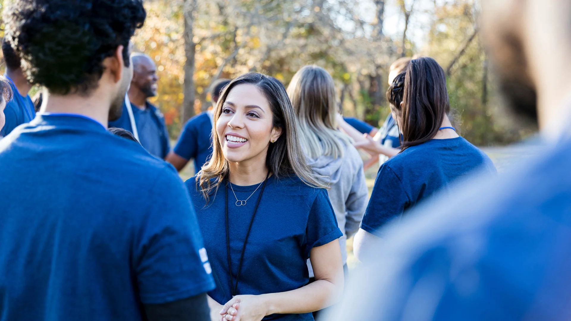 Woman in blue tshirt smiling amongst crowd